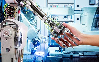 Industrierobotik. Handshake einer Roboterhand mit einer Menschenhand. Künstliche Intelligenz. 
